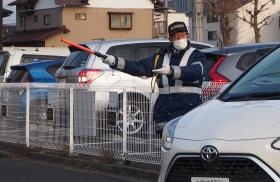 駐車場出入口にて来客の車両を誘導している様子