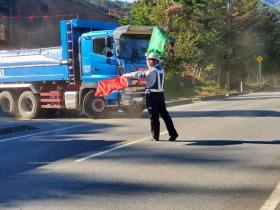道路工事現場でダンプの出入りを誘導する様子