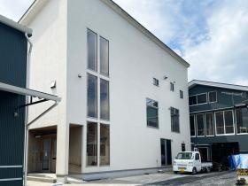 白い建物の１階が展示場２階が事務所、奥の建物が工房です。