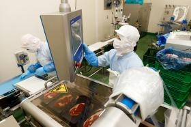 食肉加工作業の様子２ 機械を操作して肉をパック詰めする作業