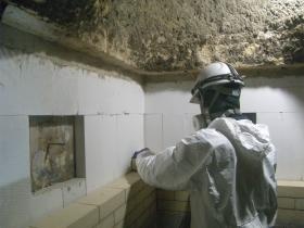 炉の内部に耐火煉瓦を積み上げている作業風景です。
