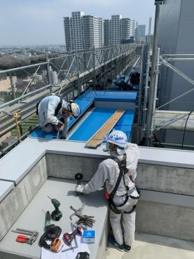 屋上に笠木を取り付けている風景です