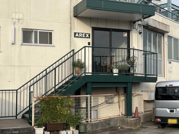 緑の階段と看板が目印です。