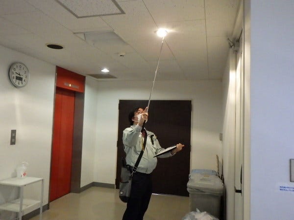 非常照明と言う器具を点検している様子です。建物内を歩きながら検査していきます。