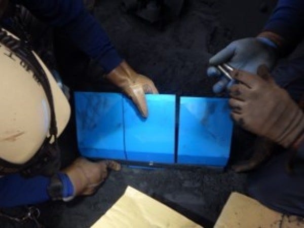 新品のクリーナーに交換しています。青色のクリーナー（スクレーパー（ヘラ））がベルトに密着し付着物を除去してくれます。