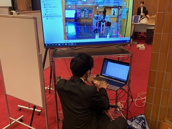 ホール入館者をチェックするAI顔認識カメラの実証実験のセットアップをしています。